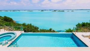 a swimming pool with a view of the water at Alta Bella Villa and Spa in Providenciales