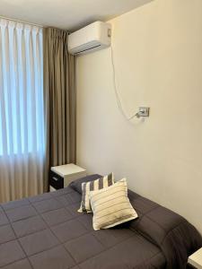 une chambre avec un lit avec un climatiseur au mur dans l'établissement Apart. Av. Corrientes, à Buenos Aires
