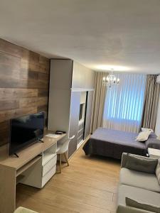 1 dormitorio con 1 cama y escritorio con TV en Apart. Av. Corrientes en Buenos Aires
