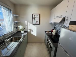 a kitchen with white cabinets and a sink and a window at La Casa di Margot - Alloggio Blu in Murazzano