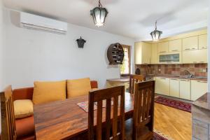a kitchen and living room with a table and a couch at Vila Sarajevo in Sarajevo
