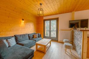 a living room with a blue couch and a table at Etoile des Vents in Morzine