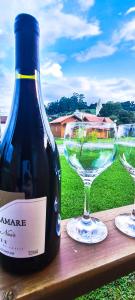 a bottle of wine and two glasses on a table at Pousada Santa Terezinha in Urubici