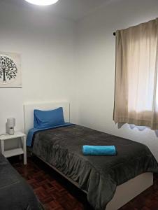Un dormitorio con una cama con una almohada azul encima. en Maresia's House, en Madalena do Mar 50 fotos más