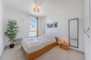 ein Schlafzimmer mit einem Bett und einem großen Fenster in der Unterkunft Le Rooftop de la Peyrière - Parking - Climatisation - 10 min de Montpellier in Saint-Jean-de-Védas