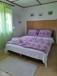 ein Bett mit einer lila Bettdecke in einem Schlafzimmer in der Unterkunft Anna Faház in Balatonmáriafürdő