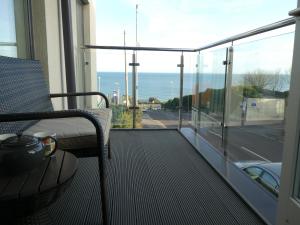 a balcony with a chair and a view of the ocean at Seaview West Coast - Exceptional - 2 Bedrooms Sleeps 5 -Stunning Sea Views - 500 metres to Beach in Bournemouth