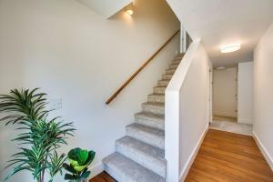 una escalera en una casa con paredes blancas y suelo de madera en Come stay at the Elm Grove Elegance Irene! en Boise