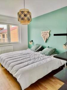 a large white bed in a room with blue walls at Maison proche du vieux Lille et de la citadelle avec place parking in Lambersart