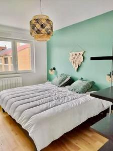 1 cama blanca grande en una habitación con paredes azules en Maison proche du vieux Lille et de la citadelle, en Lambersart