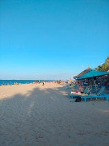 una playa con una sombrilla azul y gente en ella en Lama Beach Villa en An Bàn (2)