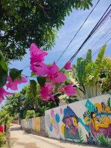 a wall with pink flowers on it next to a street at Lama Beach Villa in An Bang
