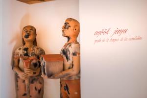 two wooden statues of men standing next to a wall at Hotel Ayook in Oaxaca City
