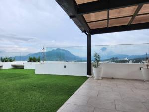 un patio con césped verde y vistas a las montañas en La Floresta en Quetzaltenango