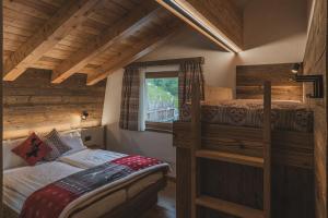 een slaapkamer met 2 stapelbedden en een raam bij Rifugio Lago Malghette in Madonna di Campiglio