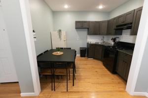 une cuisine avec une table noire et un comptoir noir dans l'établissement Cozy & Classy 3-Bed to mins NYC, à Jersey City