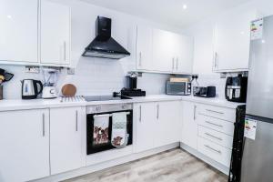 a white kitchen with white cabinets and appliances at Tranquil 3BR Retreat for Families in Bexleyheath in Bexleyheath