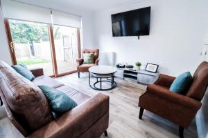 Tranquil 3BR Retreat for Families in Bexleyheath في بيكسليهيث: غرفة معيشة مع أريكة وطاولة