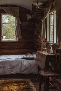 1 dormitorio con cama, mesa y ventanas en The shepherds hut at abberley glamping, en Abberley