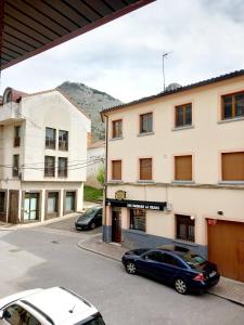 two cars parked in a parking lot in front of a building at HOTEL RURAL ORQUIDEA in Velilla del Río Carrión