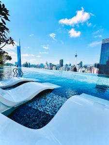 a infinity pool with a city skyline in the background at Maxx Royal Suites at Axon Kuala Lumpur in Kuala Lumpur
