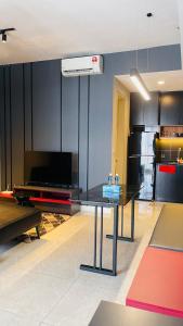 a living room with a black table and a kitchen at Maxx Royal Suites at Axon Kuala Lumpur in Kuala Lumpur