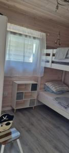a bedroom with two bunk beds and a window at domki letniskowe ŚWIĘTY SPOKÓJ in Rusinowo