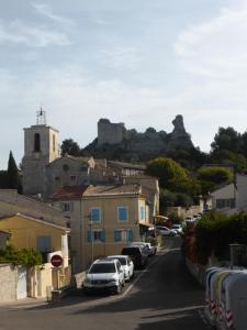 una città con auto parcheggiate in una strada con un castello di 2 chambres au calme Villa Chrisma Provence a Orgon