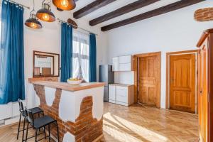 eine Küche mit einer Bar in einem Zimmer mit blauen Vorhängen in der Unterkunft Charming central apartment in Krakau