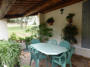 un tavolo e sedie su un patio con piante di 2 chambres au calme Villa Chrisma Provence a Orgon