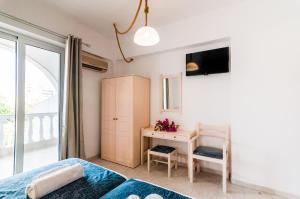 1 dormitorio con cama, escritorio y ventana en Irene Apartments, en Karpathos