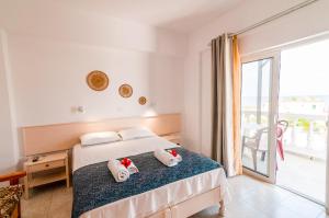 1 dormitorio con 1 cama y balcón en Irene Apartments, en Karpathos