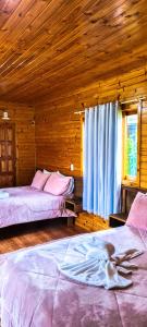 a bedroom with two beds with a woman on them at Pousada Santa Terezinha in Urubici