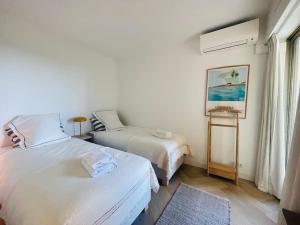 a bedroom with two beds and a window at Le Bluebay - Luxurious 2 bedrooms seaview swimming pool carpark in Cannes +13 photos