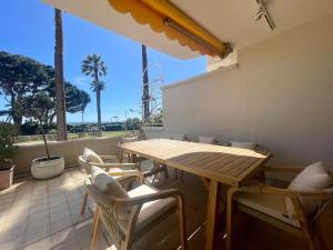 a wooden table and chairs on a patio at Le Bluebay - Luxurious 2 bedrooms seaview swimming pool carpark in Cannes