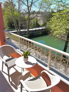 a balcony with a table and chairs and a river at Bridge House Corfu in Potamós
