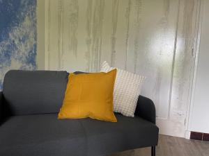 a couch with a yellow pillow on top of it at Les hyacinthes 4 in Sarlat-la-Canéda