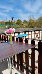 una mesa de madera con un jarrón de flores. en Hotel Libers, en Lauterbach