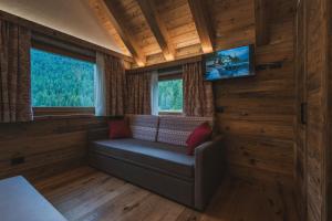 馬東納迪坎皮利奧的住宿－Rifugio Lago Malghette，小屋内的客厅配有沙发和电视