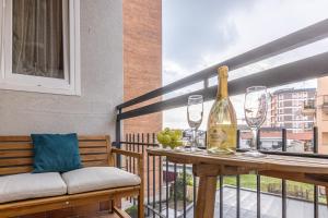 un balcón con una mesa con copas y una botella de vino en Volta 8 Apartments, en Rho