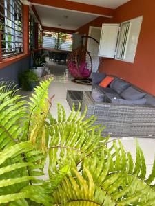 Maison Villa Dagoni في Koungou: غرفة معيشة بها نباتات خضراء وأريكة