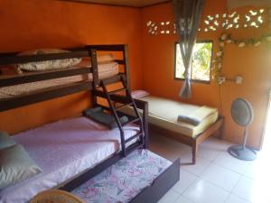 1 dormitorio con 2 literas y ventana en Cocibolca House B&B, en Altagracia