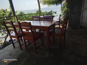 y balcón con mesa y sillas de madera. en Cocibolca House B&B, en Altagracia