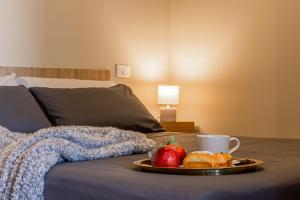 a tray with an apple and a cup of coffee on a bed at Volta 8 Apartments in Rho