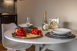 un tavolo con un piatto di pomodori e una bottiglia di vino di Comfort Home Rho Fiera a Rho Altre 7 foto