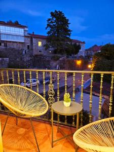 2 sillas y una mesa en el balcón por la noche en apartamentcastrotuy, en Tui