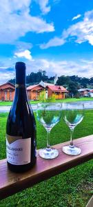 a bottle of wine and two glasses on a table at Pousada Santa Terezinha in Urubici