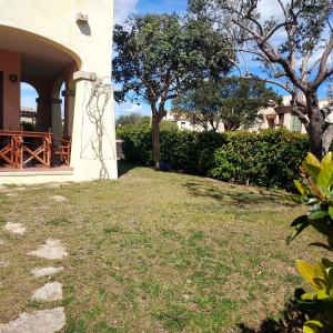 a house with a yard with grass and trees at Il Borgo - Appartamento "Taurus" in Porto San Paolo +11 photos