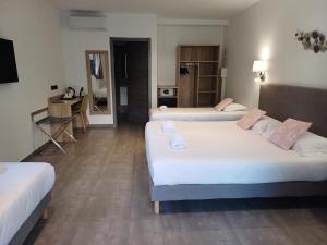a hotel room with three beds and a desk at Hôtel Casa Mea in Bastia