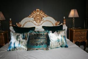 a bed with a gold and white headboard and pillows at High Dalby House in Pickering
